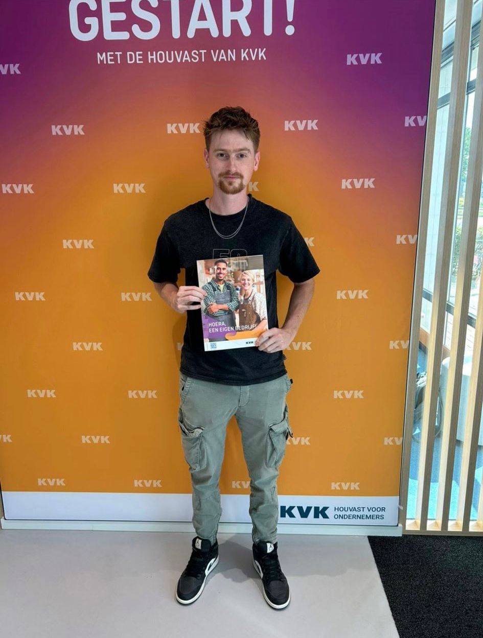 Man holding a magazine in front of a KVK branded backdrop